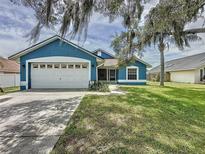 Charming single-story home with a well-manicured lawn and a two-car garage at 238 Sunridge Woods Blvd, Davenport, FL 33837