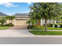 Tan single Gathering home featuring an attached garage, well-maintained landscaping, and a neatly trimmed front yard at 2736 Southland St, St Cloud, FL 34772