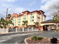 Inviting hotel exterior featuring a porte cochere, manicured landscaping, and prominent signage at 3000 Maingate Ln # 414, Kissimmee, FL 34747