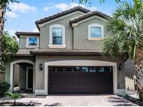 Charming two-story home featuring a tile roof and a two-car garage with tropical landscaping at 8897 Rhodes St, Kissimmee, FL 34747