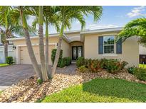 Charming single-story home with a well-manicured lawn, palm trees, and stone accents at 1703 Leatherback Ln, St Cloud, FL 34771