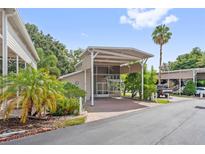 Charming home featuring a covered entrance, lush landscaping, and brick paved driveway and walkway to the front door at 2343 St George Dr, Davenport, FL 33837