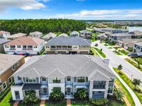 Beautiful aerial view of townhomes featuring manicured lawns and lush landscaping in a desirable community at 2698 Chantilly Ave, Kissimmee, FL 34741
