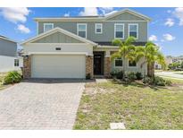 Charming two-story home featuring a two-car garage, brick accents, and freshly manicured front yard at 2759 Slash Way, St Cloud, FL 34771