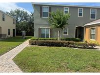 Well-maintained townhouse with green lawn, neat landscaping, and inviting walkway to covered entry at 2940 Tanzanite Ter, Kissimmee, FL 34758
