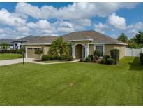 Charming single-story home with an arched entryway and meticulously manicured lawn at 301 Terranova Blvd, Winter Haven, FL 33884