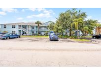 Condominium exterior with parking spaces and lush tropical landscaping at 3111 Sun Lake Ct # B, Kissimmee, FL 34747