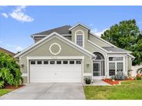 Charming home with a two-car garage and well-maintained landscaping offers great curb appeal at 3214 Herons Point Cir, Kissimmee, FL 34741
