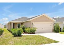 Beautiful single-story home with a well-maintained lawn and attached two-car garage at 328 Lily Ln, Davenport, FL 33837