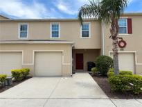 Charming townhouse featuring a one-car garage, neutral paint, and well-maintained landscaping at 359 Arbor Lakes Dr, Davenport, FL 33896