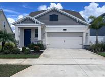 Charming single-Gathering home featuring a two-car garage, well-maintained landscaping, and a welcoming blue front door at 4424 Seven Canyons Dr, Kissimmee, FL 34746