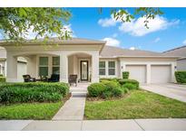 Charming single-story home featuring a well-manicured lawn, covered porch, and a two-car garage at 4918 Wildwood Pointe Rd, Winter Garden, FL 34787
