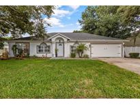 Charming single-story home with a well-manicured lawn, arched windows, and an attached two-car garage at 512 Yellow Tail Pl, Chuluota, FL 32766