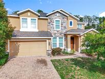 Inviting two-story home showcasing a beautiful stone facade and a well-manicured front yard at 771 Cavan Dr, Apopka, FL 32703