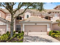 Charming townhome featuring a well-maintained tile roof, two-car garage, and beautifully landscaped front yard at 8401 Riverdale Ln # 8401, Davenport, FL 33896