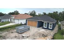 New construction home featuring a dark blue exterior, white trim, and an unfinished yard at 1522 Pine St, Orlando, FL 32824