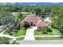 Stunning single-story home boasting lush landscaping, a circular driveway, and a tile roof at 2402 Raven Croft Ct, Orlando, FL 32837
