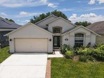 Charming one-story home featuring stucco siding, well-manicured landscaping, and an attached two-car garage at 2807 Playing Otter Ct, Kissimmee, FL 34747