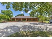 Spacious brick home featuring a circular driveway and mature trees, offering a blend of classic style and natural beauty at 3181 Canter Ln, Kissimmee, FL 34746