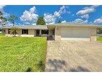 Charming single-story home with a well-manicured lawn and attached two-car garage at 4125 Packard Ave, St Cloud, FL 34772