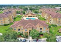 An aerial view of a residential community featuring a pool and manicured grounds at 504 Terrace Ridge # 311, Davenport, FL 33896