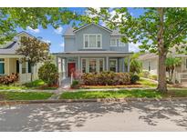 Charming two-story home featuring a welcoming front porch and lush landscaping at 6905 Beargrass Rd, Harmony, FL 34773