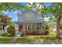 Charming two-story home with a front porch, landscaped yard, and a vibrant red door at 6905 Beargrass Rd, Harmony, FL 34773