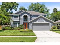 Charming two-story home with a manicured lawn, beautiful landscaping, and an attached two-car garage at 716 Timberwilde Ave, Winter Springs, FL 32708