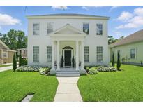 Classic two-story white home with columns, landscaped front yard, and inviting entrance at 933 Jasmine St, Celebration, FL 34747