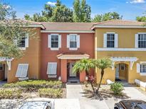 Charming multi-colored townhome featuring a red tile roof, white trim, and a well-manicured front yard at 1129 Park Ridge Cir, Kissimmee, FL 34746