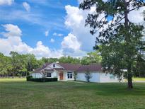 Charming single-story home with orange front door and a well-manicured lawn on a sunny day at 1781 Terra Verde Ln, Chuluota, FL 32766