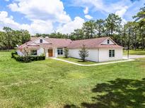 Charming single-story home features a well-manicured lawn, mature trees, and a welcoming facade at 1781 Terra Verde Ln, Chuluota, FL 32766