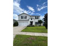 Charming two-story home with a well-manicured lawn and beautiful landscaping at 293 Fiddlewood Ct, Davenport, FL 33837