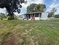 Exterior view of home with screened porch and grassy lawn at 3050 Old Soldier Rd, Lakeland, FL 33810