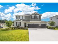 Charming two-story home featuring a three car garage, manicured lawn, and impeccable landscaping at 31792 Broadwater Ave, Leesburg, FL 34748