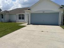 Charming home featuring an attached garage and a well-maintained lawn at 343 Marquee Dr, Kissimmee, FL 34758