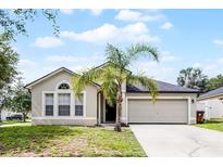 Charming single-story home with a well-manicured lawn and a beautiful palm tree in the front yard at 447 Hammerstone Ave, Haines City, FL 33844