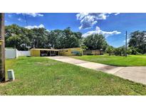 Charming single-story home with a covered parking, lush lawn, and mature trees offering shade at 518 Oranole Rd, Maitland, FL 32751