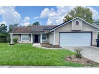 Charming one-story home features a well-maintained front yard, a two-car garage, and solar panels on roof at 5230 Clarion Oaks Dr, Orlando, FL 32808