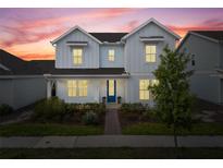 Charming two-story home with blue trim and a well-manicured lawn, illuminated by the warm colors of dusk at 6522 Rover Way, St Cloud, FL 34771