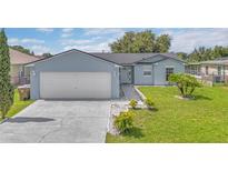 Charming single-story home featuring a two-car garage and well-manicured front yard at 107 Whitehall Way, Kissimmee, FL 34758