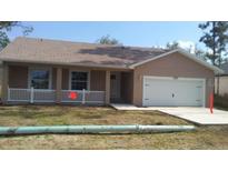 Charming single-story home with a well-maintained lawn, cozy front porch, and an attached two-car garage at 110 Sparrow Ct # 9, Kissimmee, FL 34759