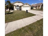 Charming single-story home with a well-maintained lawn and a two-car garage at 123 Moss Bluff Rd, Kissimmee, FL 34746