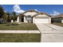 Charming single-story home with a well-manicured lawn and mature palm trees at 123 Moss Bluff Rd, Kissimmee, FL 34746