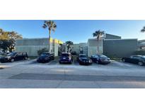 Condo building with parking lot in front, features well-maintained landscaping and palm trees at 167 Scottsdale Sq # 167, Winter Park, FL 32792