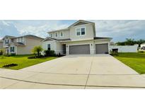 Two-story home featuring a light gray exterior, well-manicured lawn, and an attached two-car garage at 2508 W End Dr, St Cloud, FL 34772