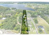 An aerial view of a lot showing its boundaries and surroundings including trees and a lake in the background at 2571 Ames Haven Rd, Kissimmee, FL 34744