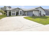 Charming single-story home with manicured lawn and long driveway leading to a two-car garage at 2626 Gentre St, Kissimmee, FL 34744