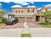 Inviting two-story home featuring a brick driveway and a two-car garage at 2690 Pleasant Cypress Cir, Kissimmee, FL 34741