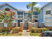 Inviting two-story condo with a beautiful blue exterior, lush landscaping, and a charming gated entrance at 2737 N Poinciana Blvd # 92, Kissimmee, FL 34746